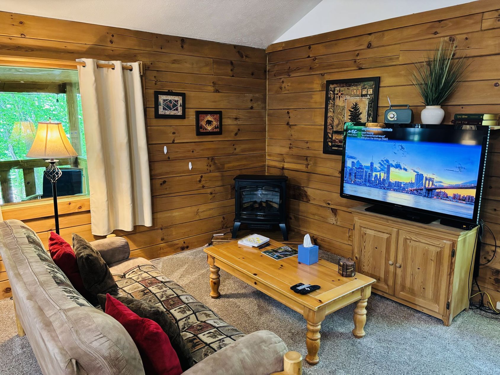 Gas fireplace and television above the pine coffee table at Aspen Cabin