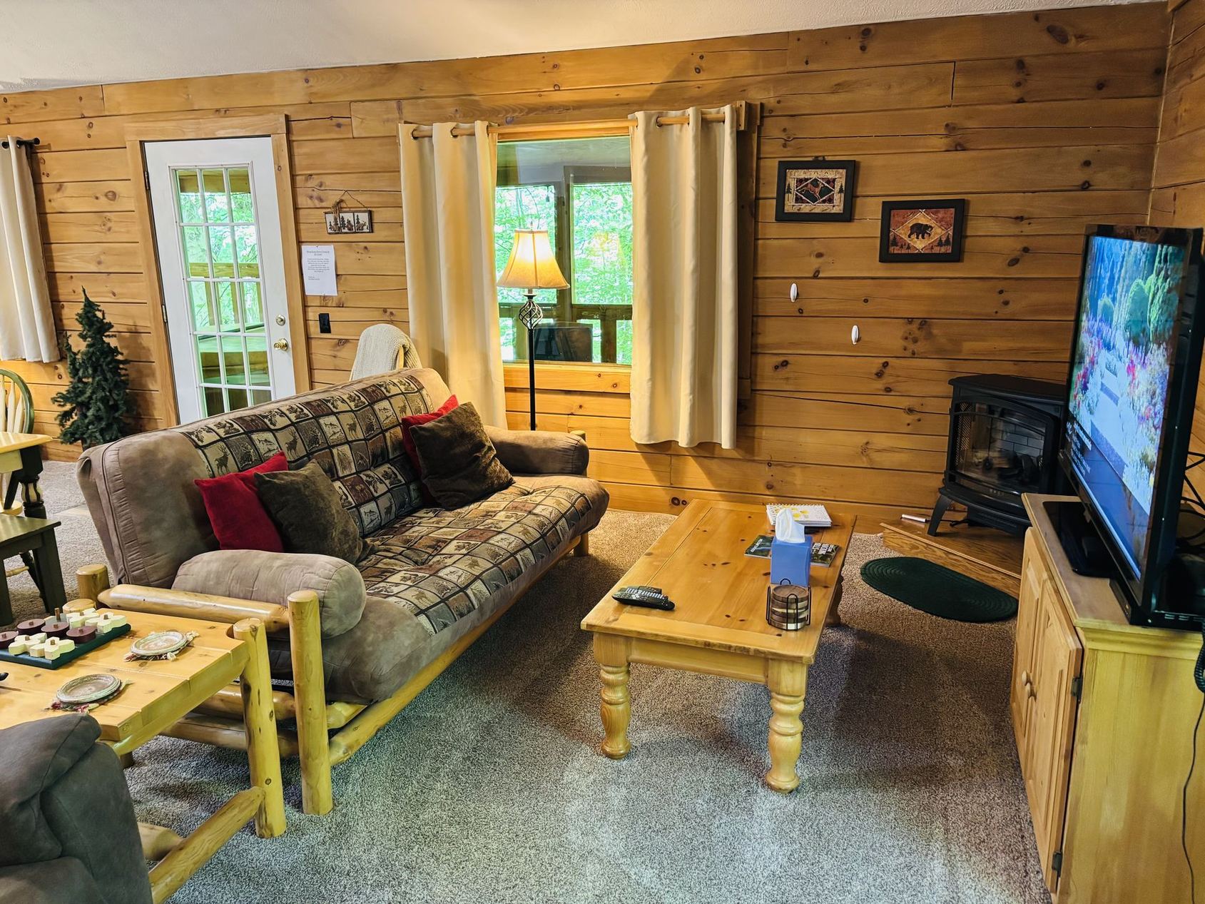 Log-frame futon, gas fireplace and television in the sitting area at Aspen Cabin