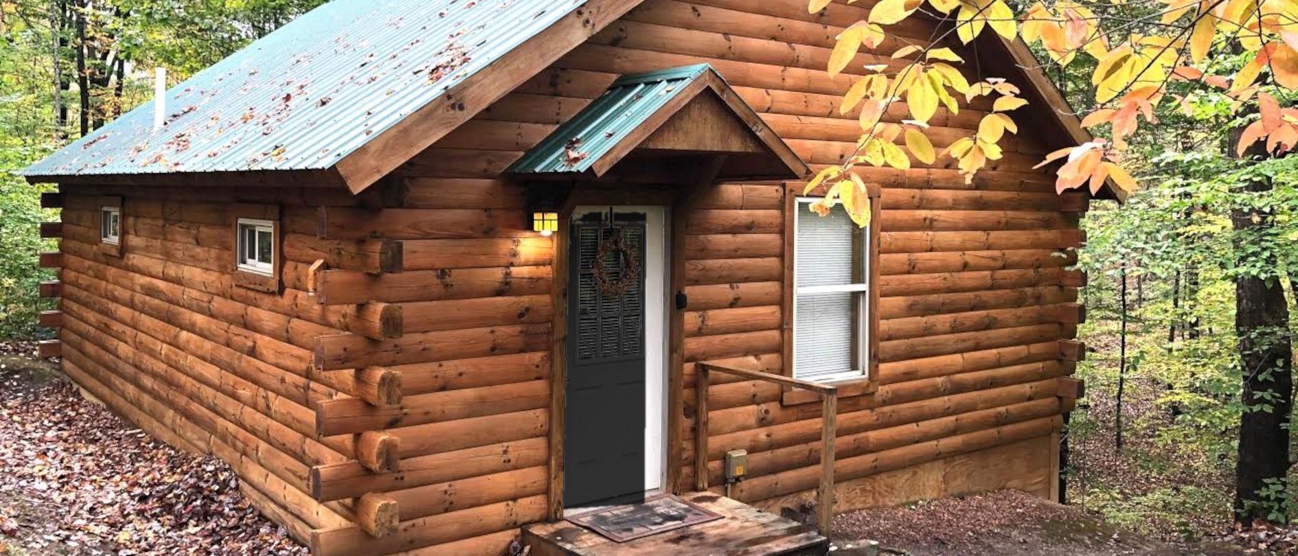 A log cabin at Bear Run under a green metal roof