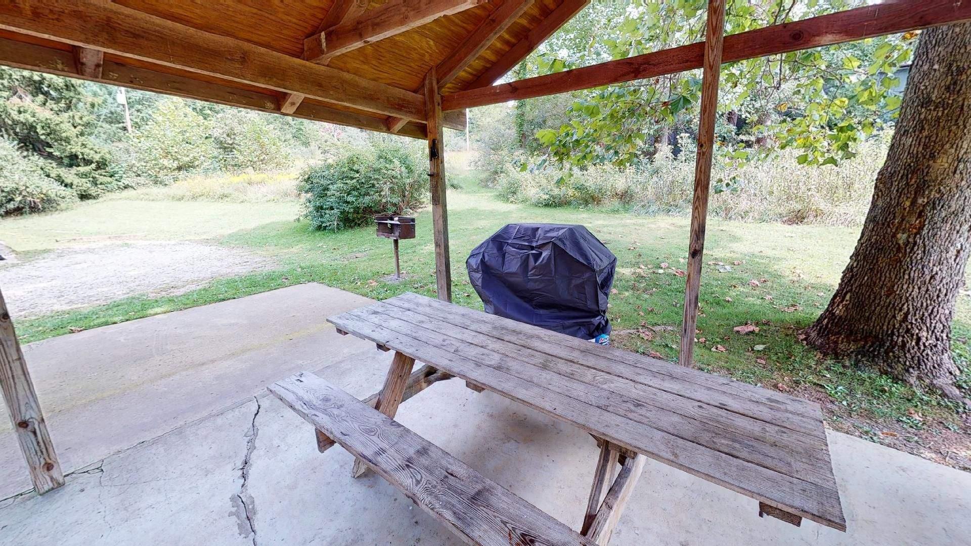 The shelter house at Red Oak Cabin, with a picnic table and gas grill