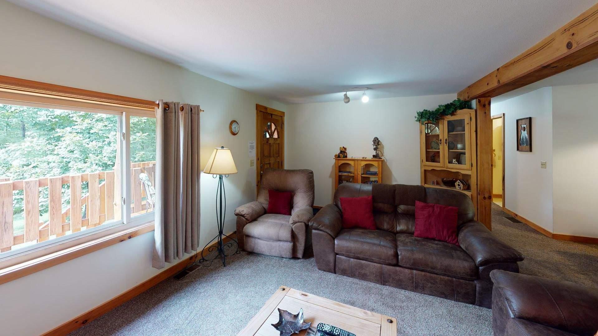 Leather sofa and recliner in the living room at Red Oak Cabin, with a window over the deck