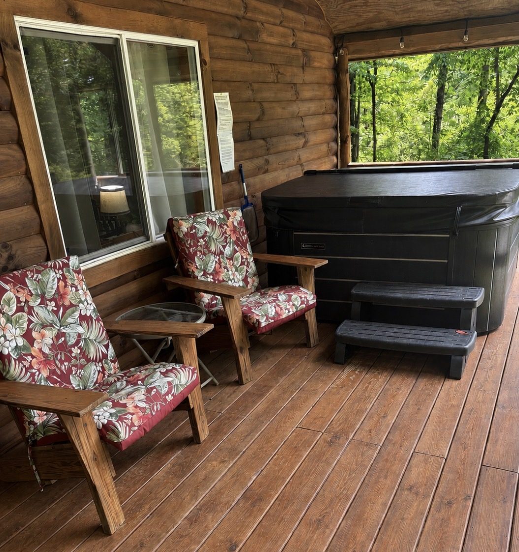 Covered deck with a private outdoor hot tub at Sugar Maple Cabin