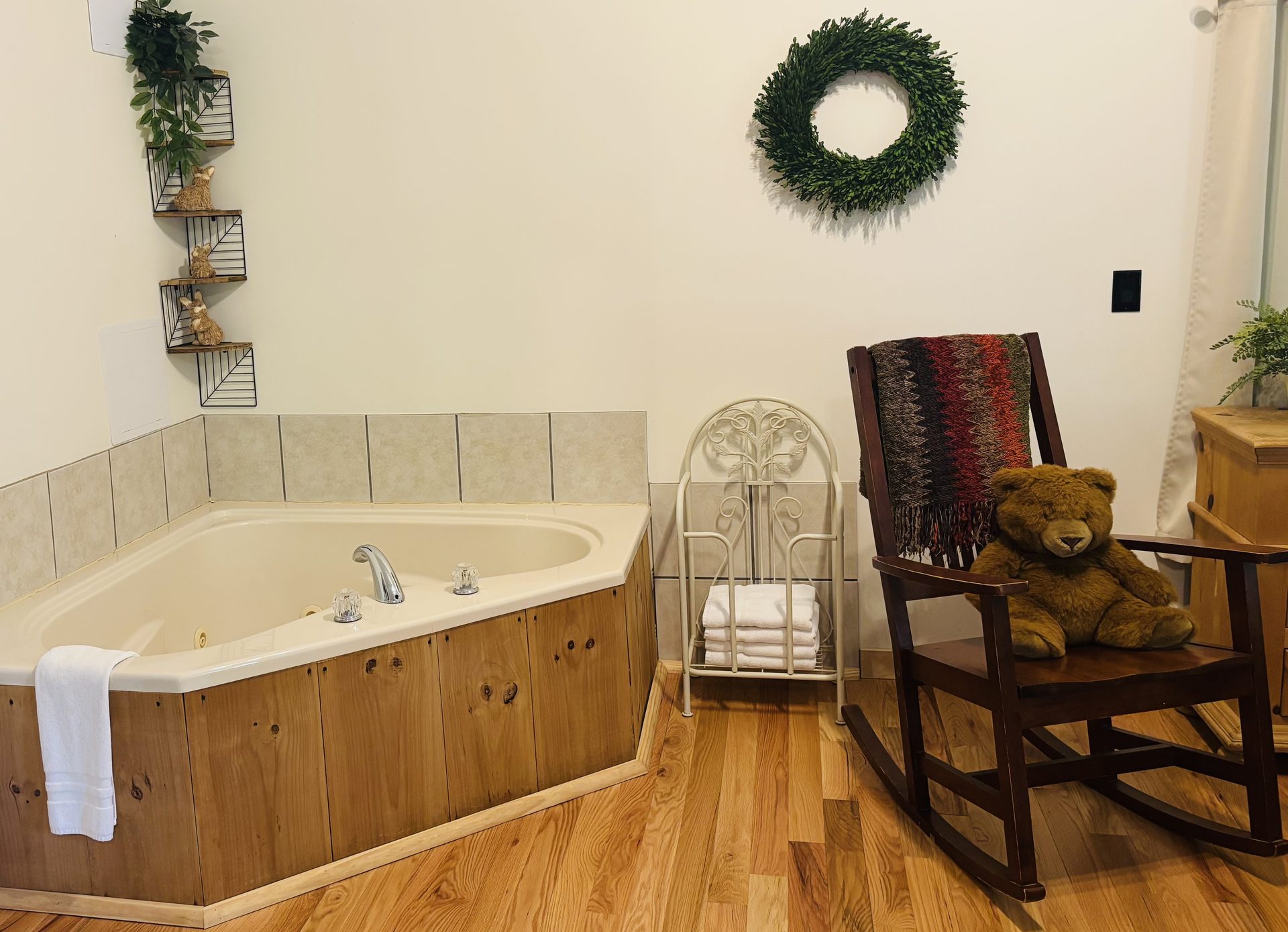 Indoor jacuzzi corner garden tub with fresh towels and a rocking chair at Sugar Maple Cabin