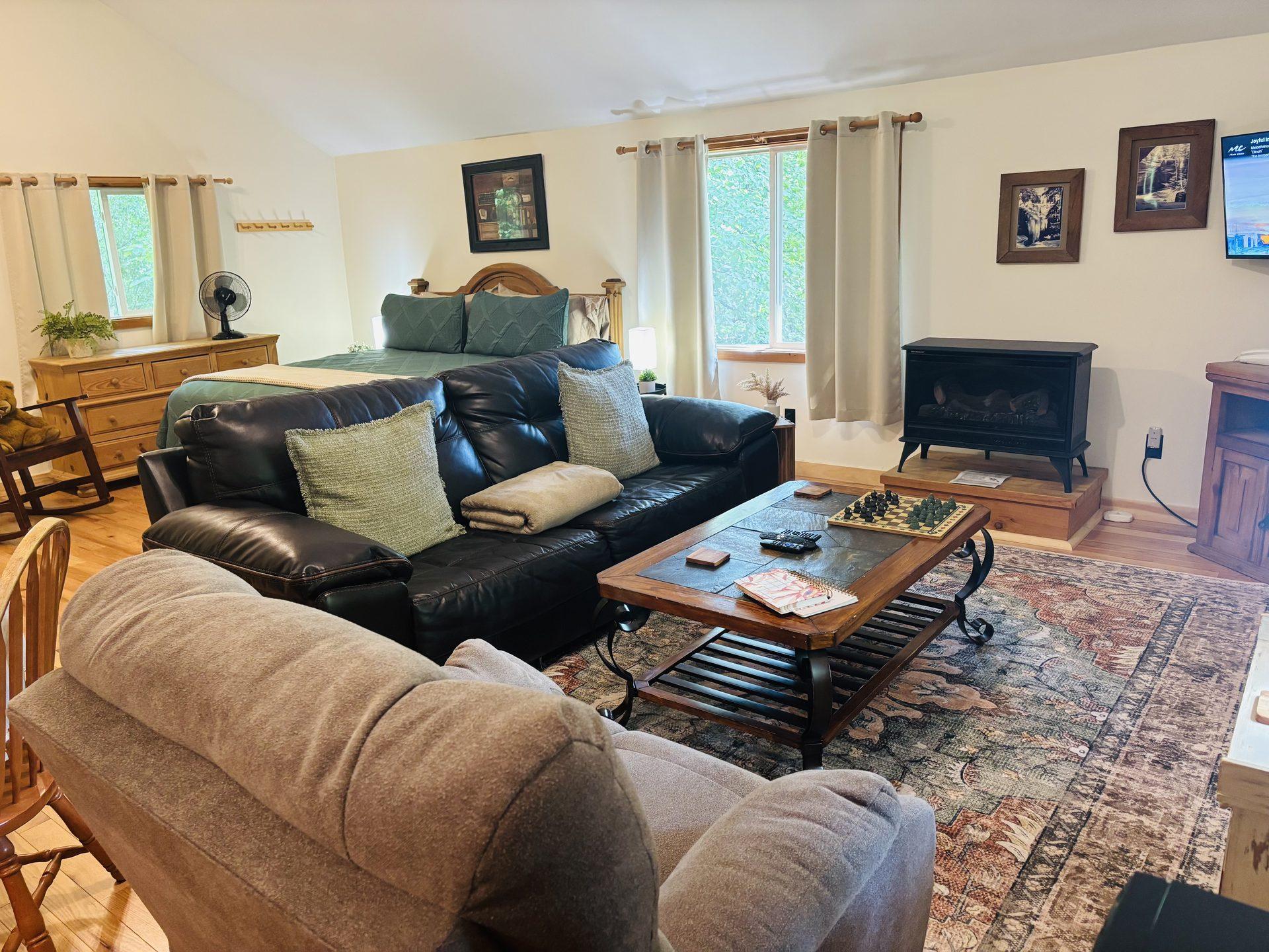 Leather sofa and gas fireplace facing the king bed at Sugar Maple Cabin