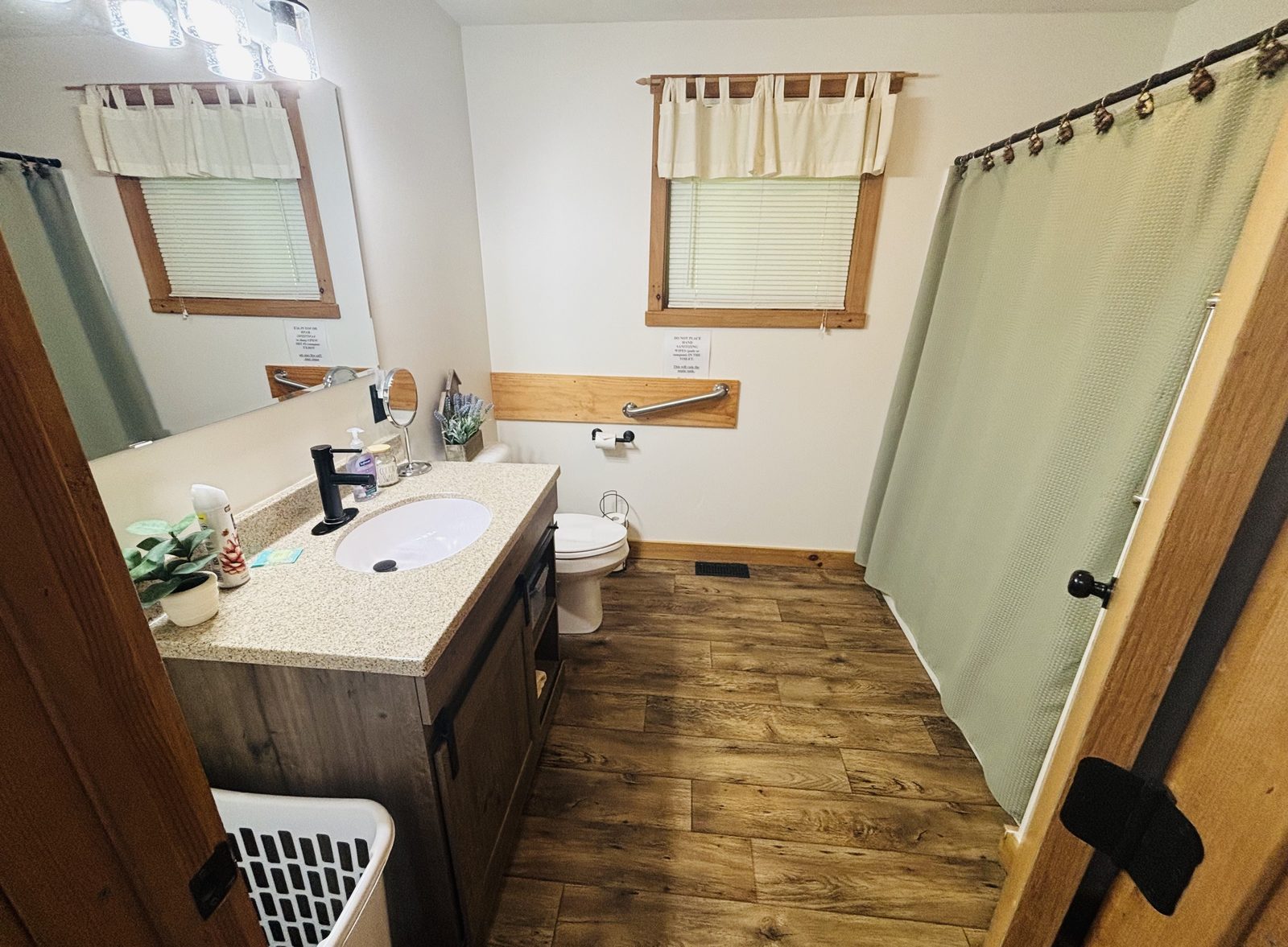 A full bath at Red Oak Cabin with a vanity, mirror, shower and two windows