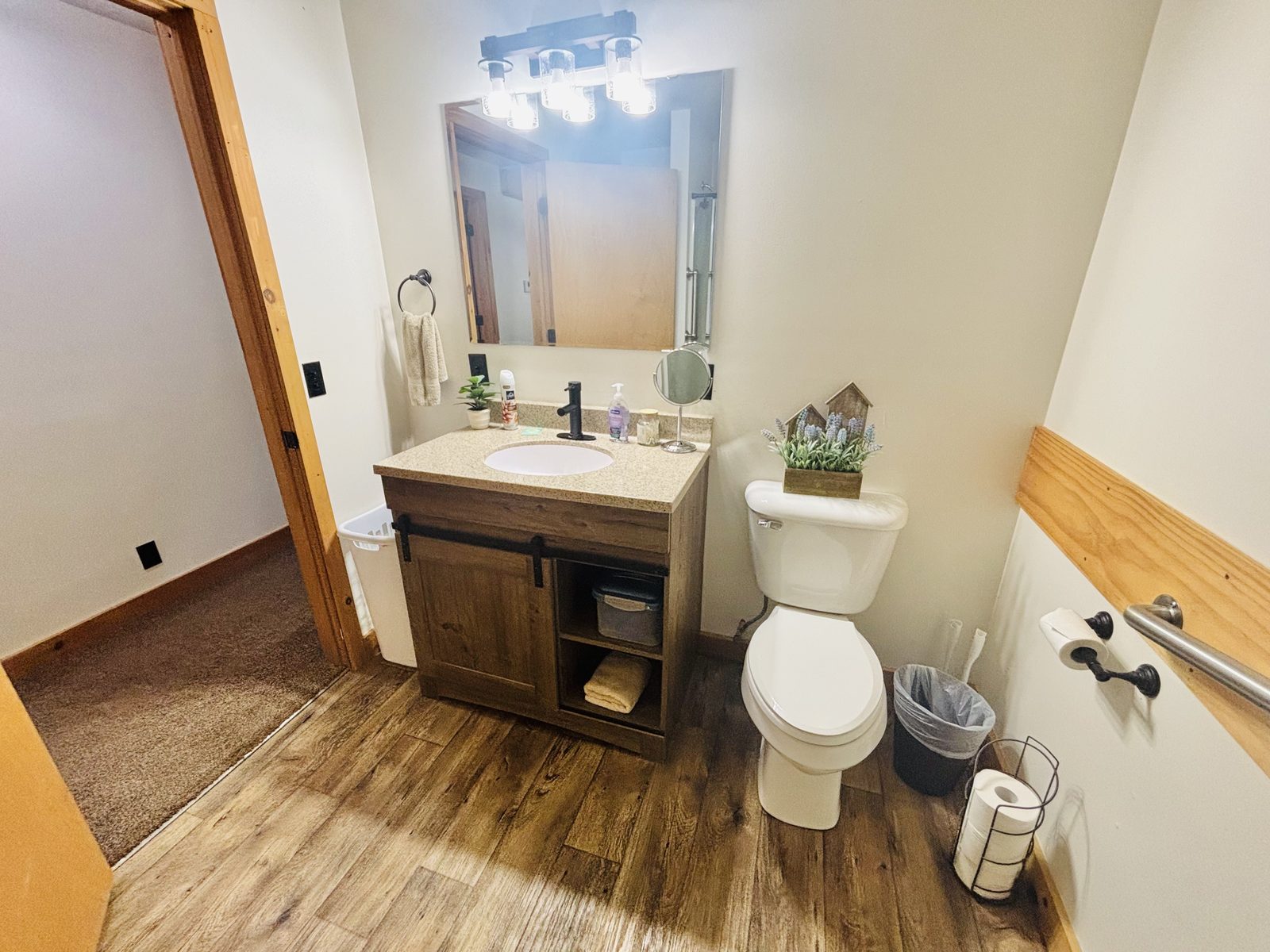 The second full bath at Red Oak Cabin, with a wood vanity and black fittings