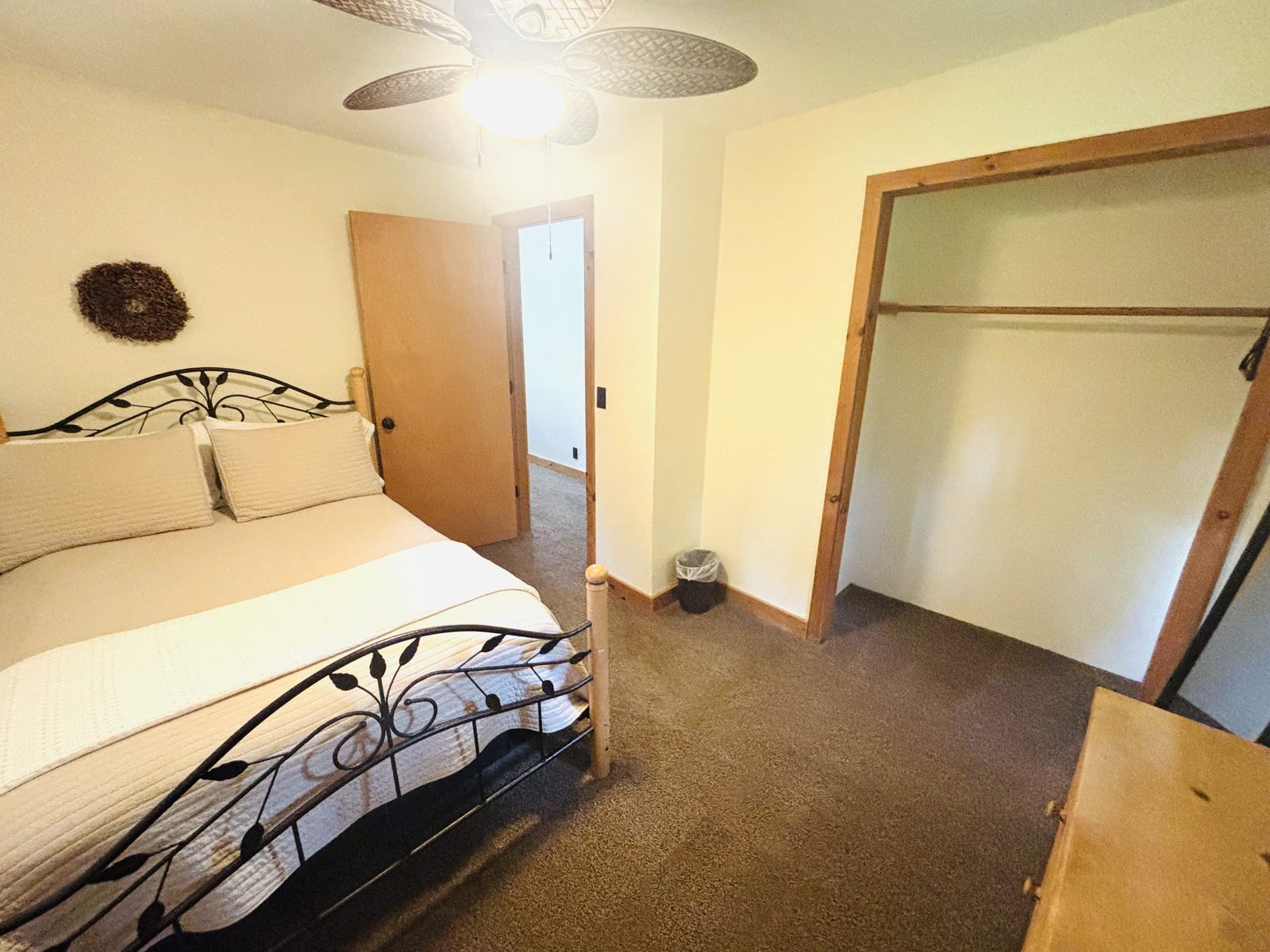 A bedroom at Red Oak Cabin with white bedding, a scrolled iron bed and a wide closet