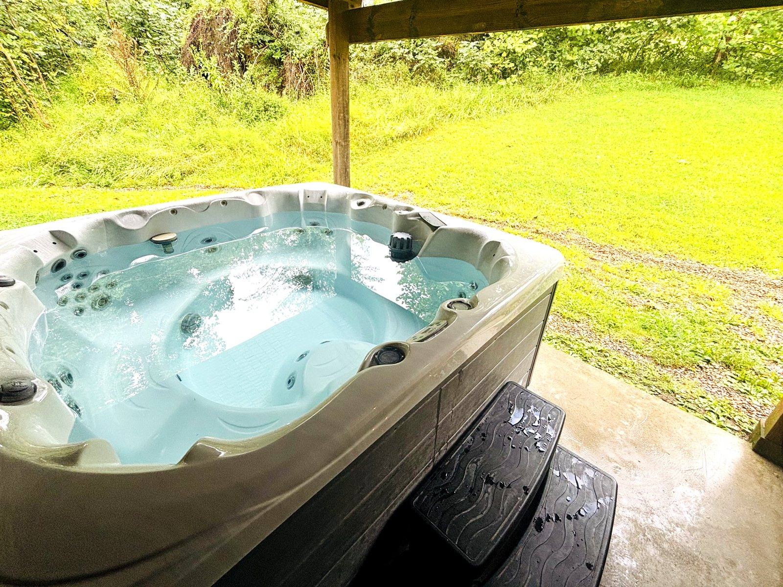 The private hot tub at Red Oak Cabin, under cover on its own pad beside the lawn