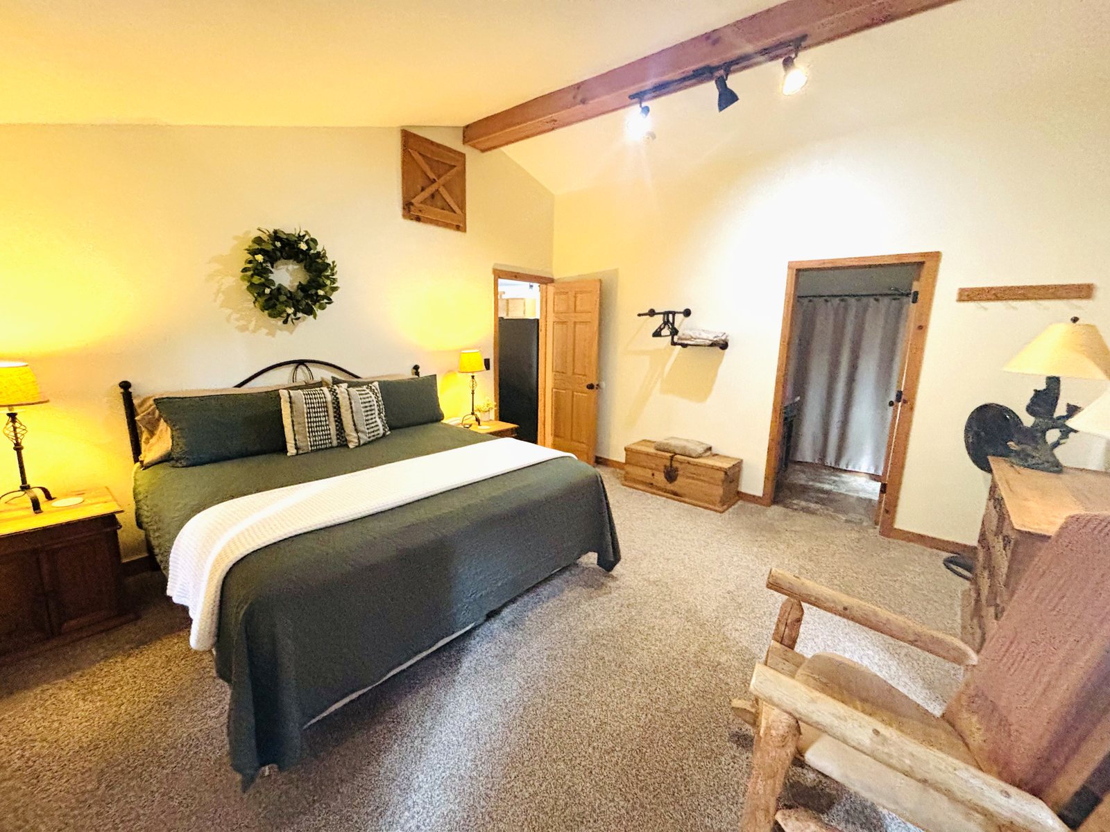 Master bedroom at Red Oak Cabin — king bed under a vaulted ceiling, with an ensuite through