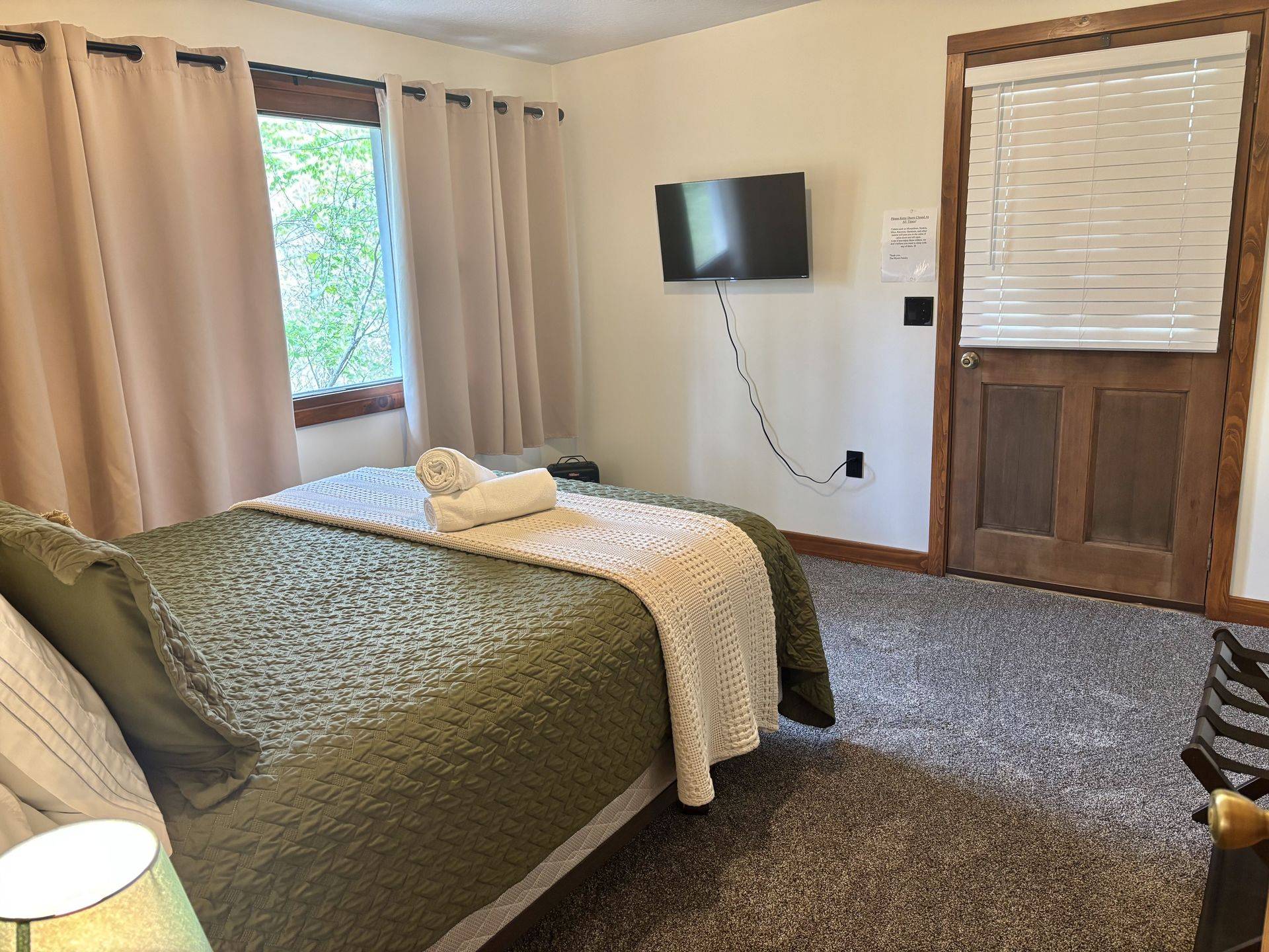 A downstairs bedroom at Redbud Cabin with a television and its own door outside