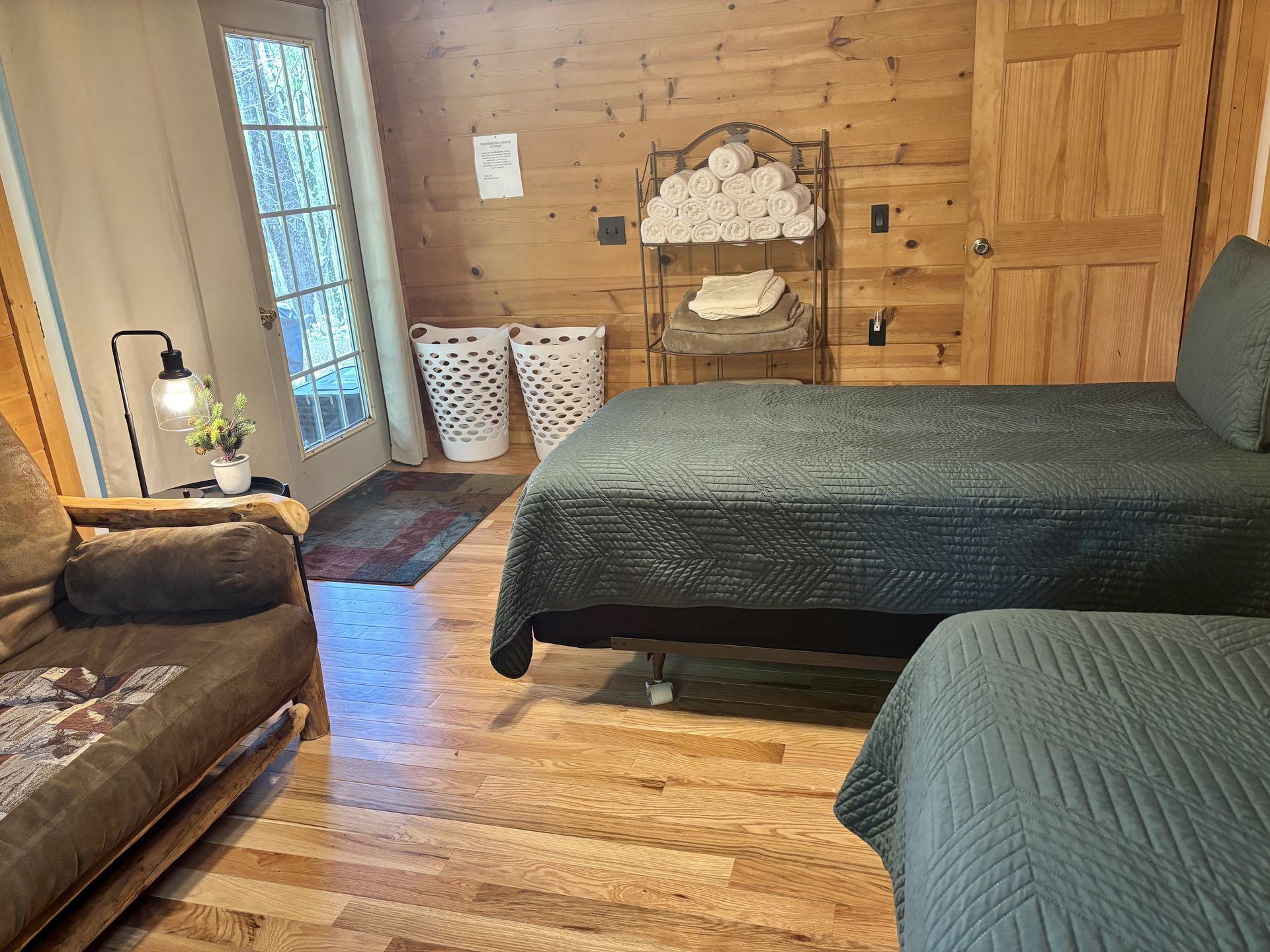The twin-bedded room at Redbud Cabin, two beds against pine panelling