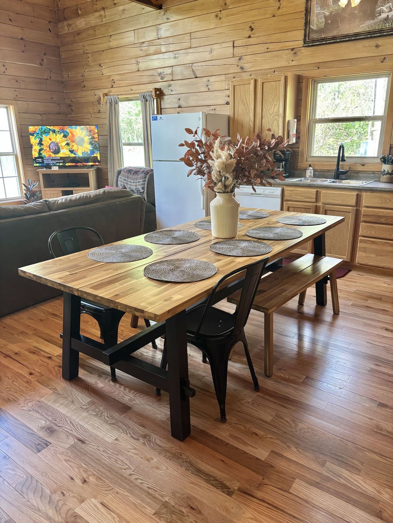 Farmhouse dining table seating six beside the full kitchen at Redbud Cabin