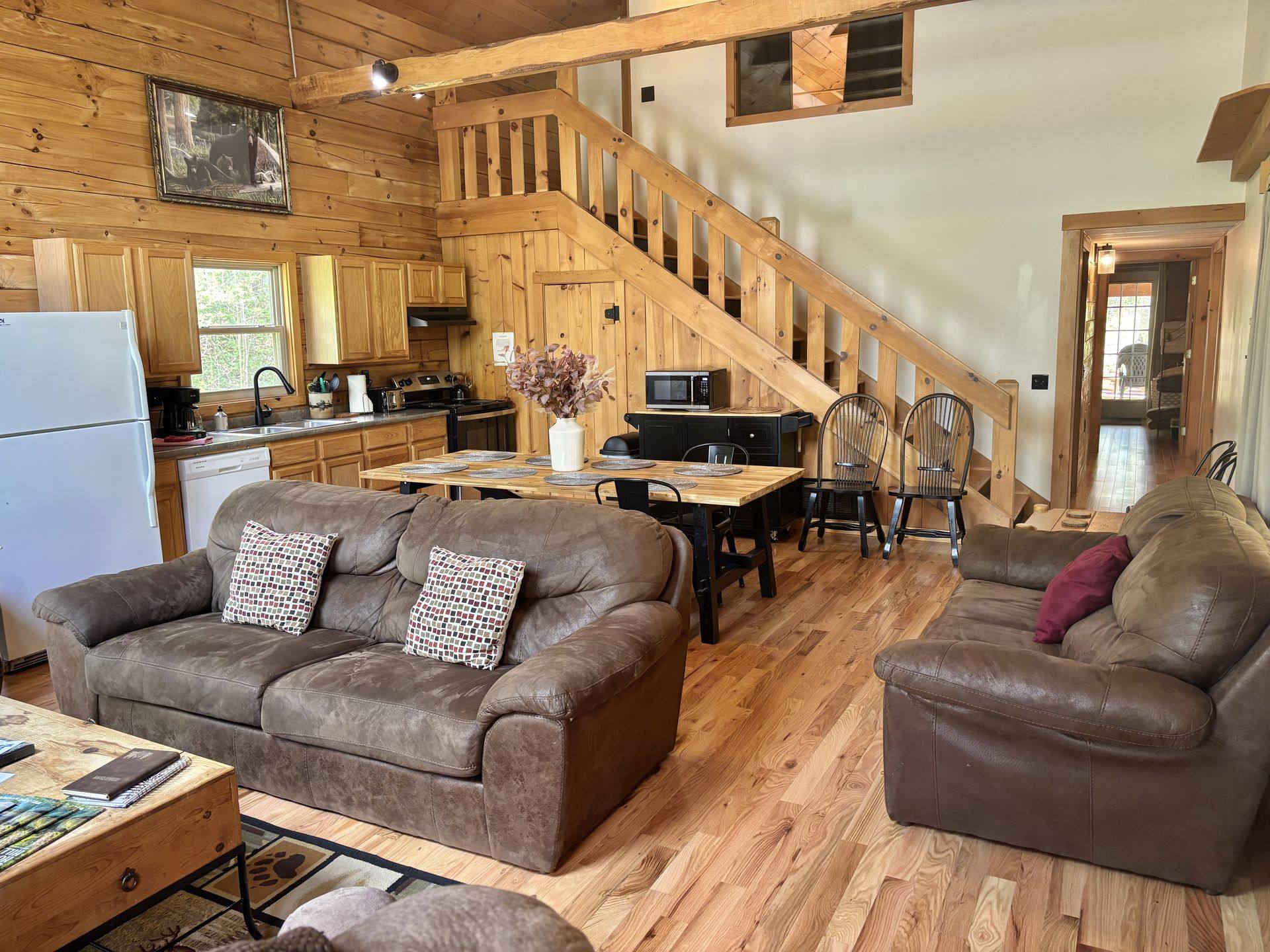 Living room at Redbud Cabin looking through to the kitchen and the stairs to the loft