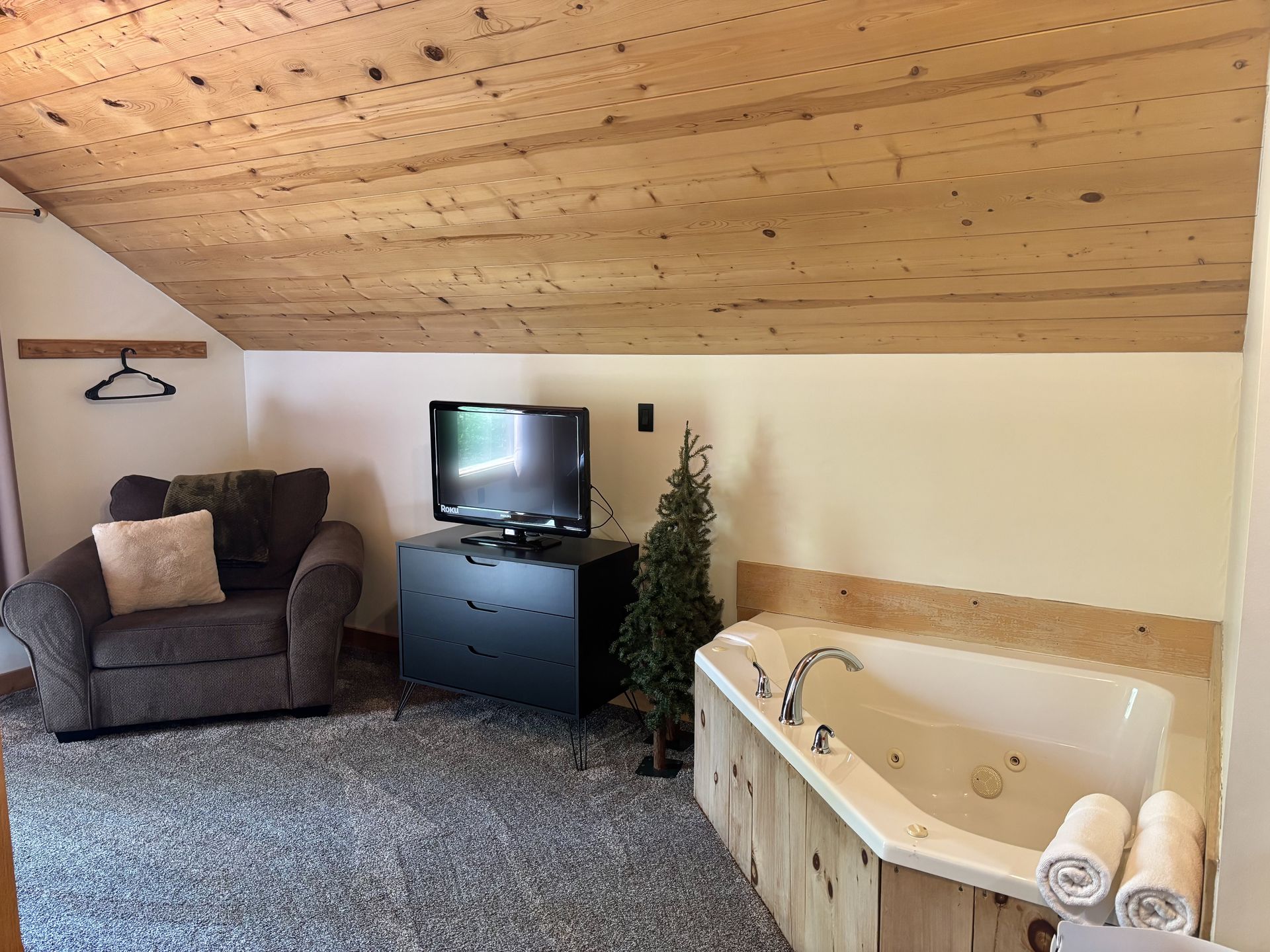 Corner jacuzzi tub and television in the loft master at Redbud Cabin