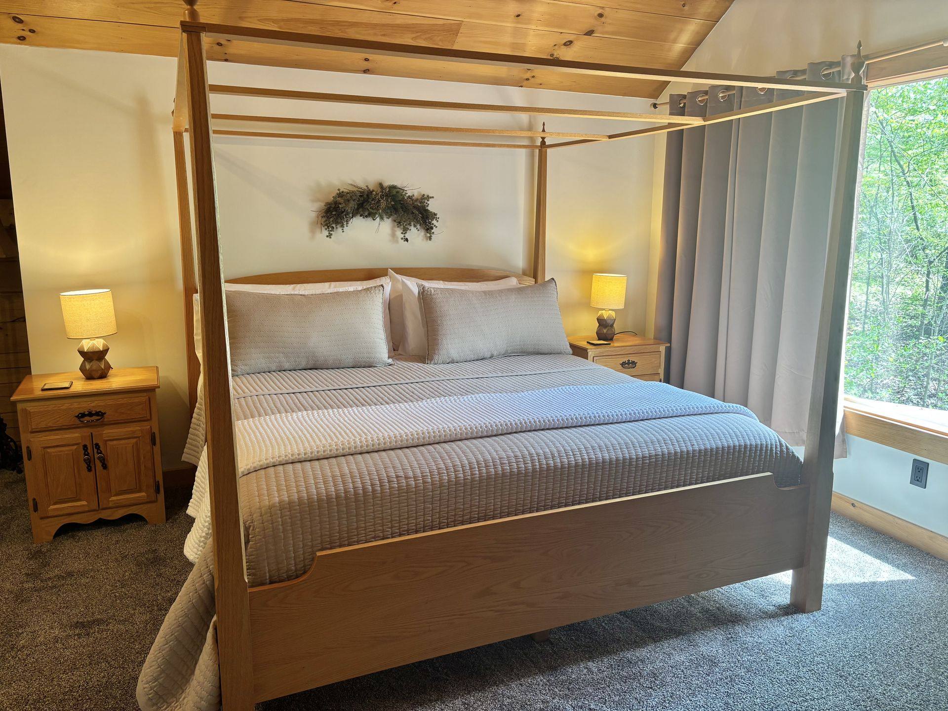 The king four-poster in the upstairs master at Redbud Cabin